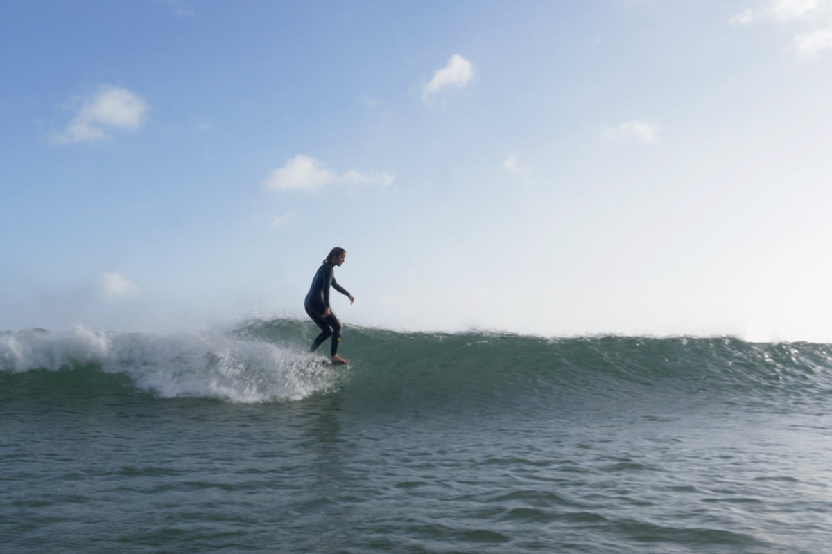 surfer beth leighfield noseriding on her longboard wearing a nuwave natural rubber wetsuit