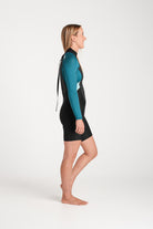 Beth wearing a black and teal spring wetsuit on a white background