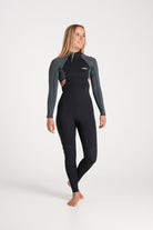 Beth wearing a black and forest green wetsuit on a white background