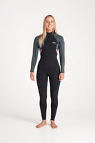 Beth wearing a black and forest green wetsuit on a white background