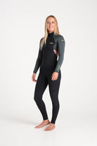 Beth wearing a black and forest green wetsuit on a white background