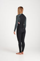 Beth wearing a black and forest green wetsuit on a white background