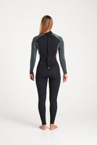 Beth wearing a black and forest green wetsuit on a white background