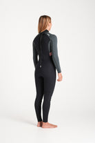 Beth wearing a black and forest green wetsuit on a white background