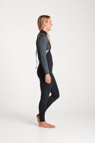 Beth wearing a black and forest green wetsuit on a white background